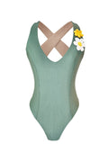 Green ribbed swimsuit with criss-cross straps and white daisy details on a white background